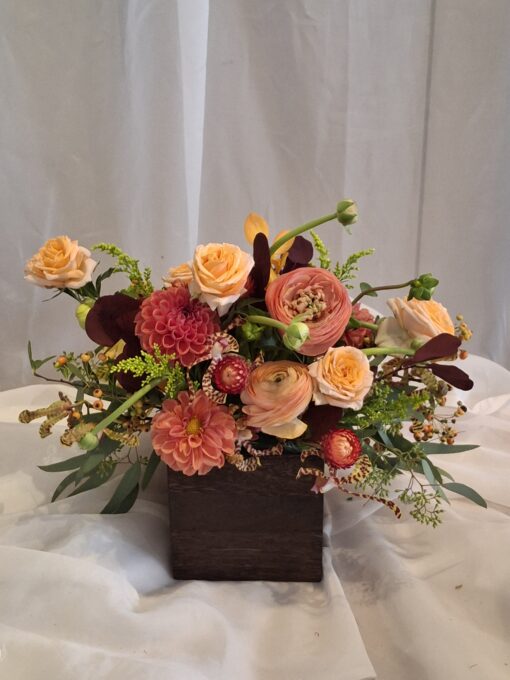 Our Fall arrangement has peach roses,dahlias, ranunculus and mokara orchids