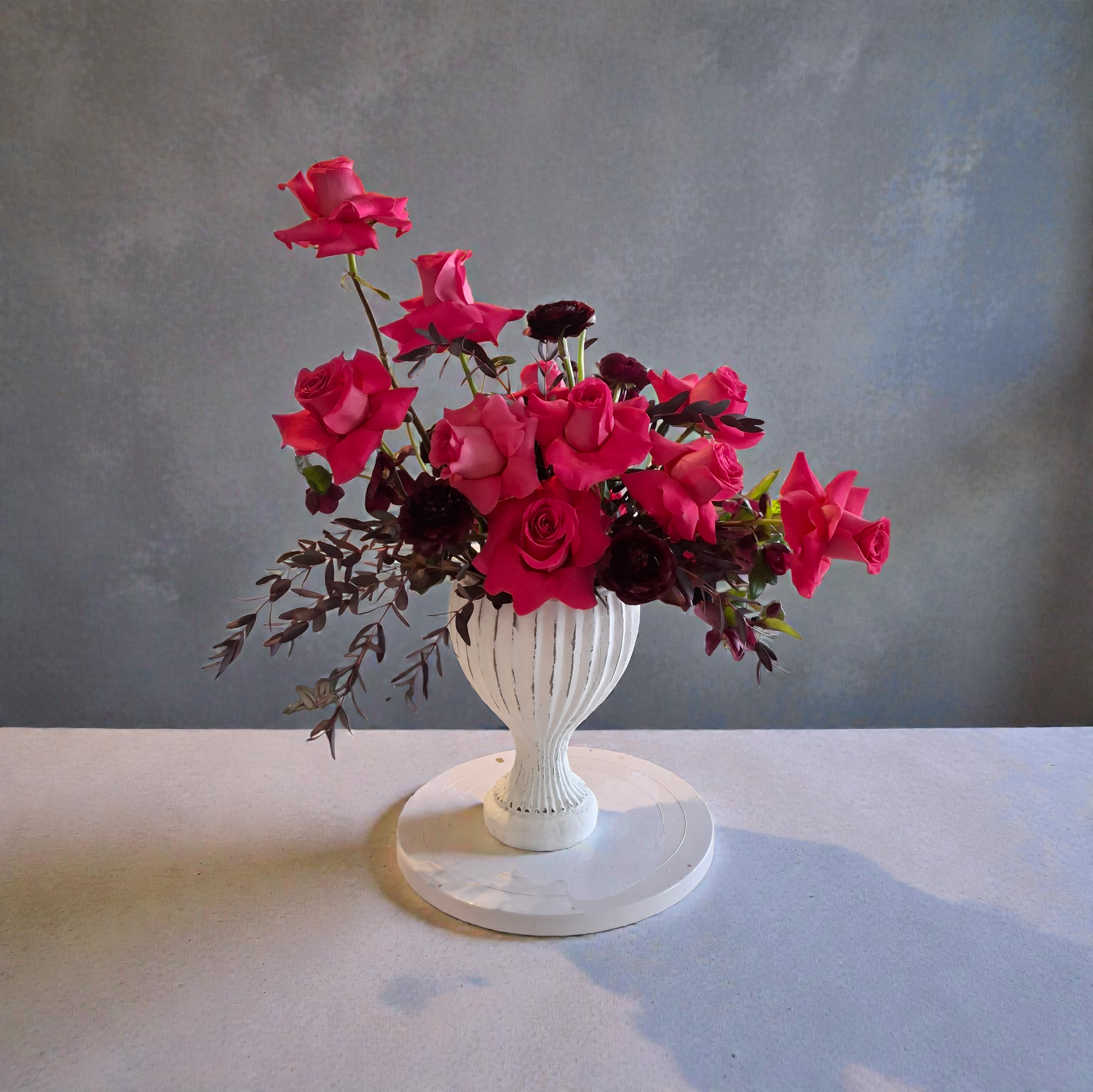 This deep and dark arrangement is sure to excite that special person in your life. With Pink Floyd roses and dark color ranunculus it's a dreamy treat.